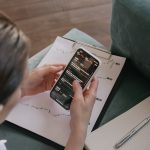 Mulher analisando dados financeiros e gráficos em um smartphone