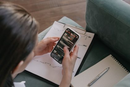 Mulher analisando dados financeiros e gráficos em um smartphone