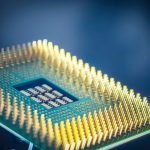 Close-up de um chip de processador com contatos dourados sobre fundo azul.