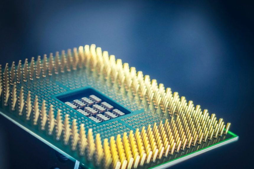 Close-up de um chip de processador com contatos dourados sobre fundo azul.